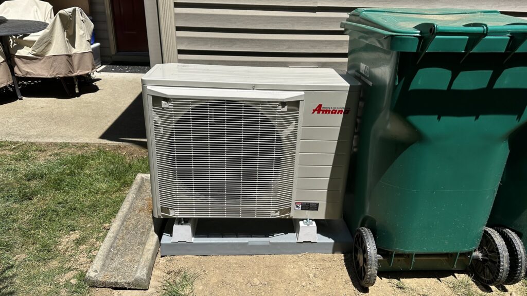 An outdoor heat pump or air conditioning unit installed next to a residential building, maintained by Prime Home HVAC in York, PA.