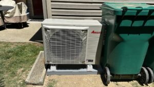 An outdoor heat pump or air conditioning unit installed next to a residential building, maintained by Prime Home HVAC in York, PA.