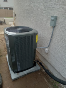 An outdoor HVAC condenser unit recently installed by Dolphin Air Conditioning & Refrigeration in Mesa, AZ.