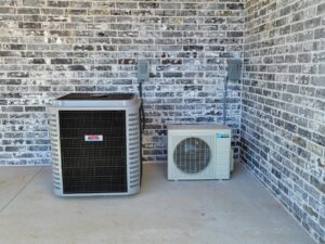 An outdoor HVAC condenser unit and a mini-split outdoor unit installed by Fusion Heat and Air in Fort Smith, AR.