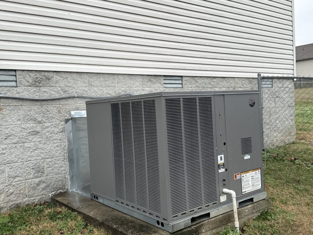 An outdoor HVAC condenser unit installed next to a residential building by AirTemp Heating & Cooling in Nashville, TN.