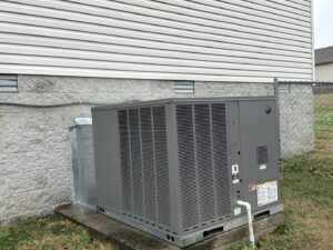 An outdoor HVAC condenser unit installed next to a residential building by AirTemp Heating & Cooling in Nashville, TN.