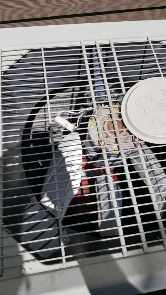 The top view of an outdoor HVAC condenser unit with its fan blades, serviced by Air Conditioning and Heating Service of Meridian, ID