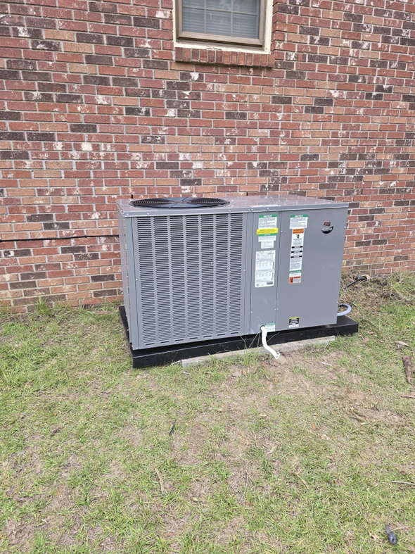 An outdoor HVAC condenser unit installed next to a brick house by GS Heating and Air LLC in West Columbia, SC