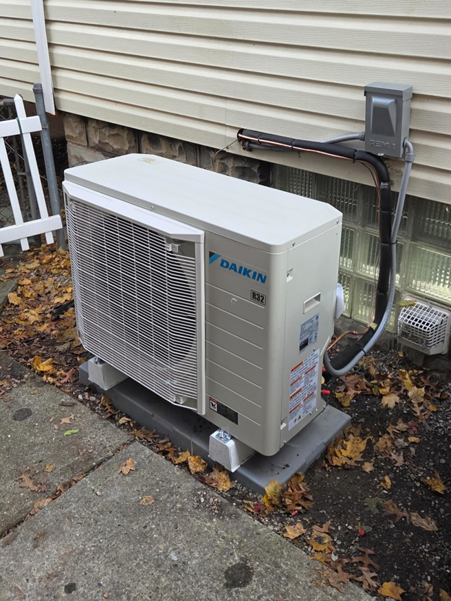 An outdoor HVAC condenser unit installed next to a residential building by Berkshire Heating and Cooling in Pittsburgh, PA