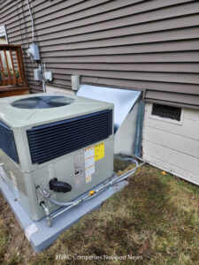 An outdoor HVAC condenser unit newly installed next to a residential building by Cannon Heating and Air Conditioning, LLC in Newport News, VA.