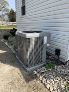 A newly installed outdoor HVAC condenser unit next to a residential building by Coastal Breeze Heating-Cooling-Plumbing in Hampton, VA.