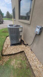 An outdoor HVAC condenser unit installation next to a commercial building by Grand Slam Heating & Air in Baton Rouge, LA.