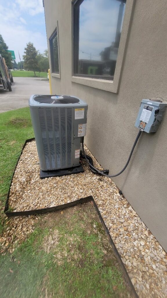 An outdoor HVAC condenser unit installation next to a commercial building by Grand Slam Heating & Air in Baton Rouge, LA.