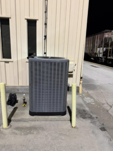 A newly installed or serviced outdoor HVAC condenser unit next to a commercial building by Indoor Weather Solutions LLC in Broken Arrow, OK.