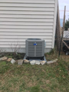 An outdoor HVAC condenser unit installation next to a residential building by James HVAC LLC in Georgetown, DE.