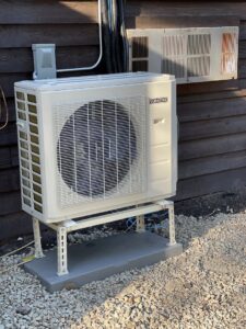 A newly installed Durastar outdoor HVAC condenser unit on a stand next to a building by Jones Heating and Refrigeration in Dickinson, ND.