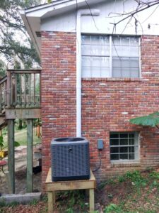 A newly installed outdoor HVAC condenser unit next to a residential building by Sterling Service of Florida Inc in Tallahassee, FL.