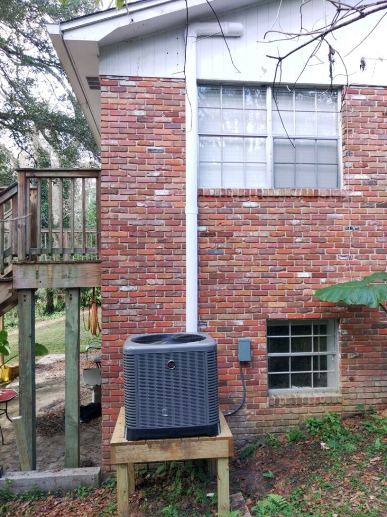 A newly installed outdoor HVAC condenser unit next to a residential building by Sterling Service of Florida Inc in Tallahassee, FL.