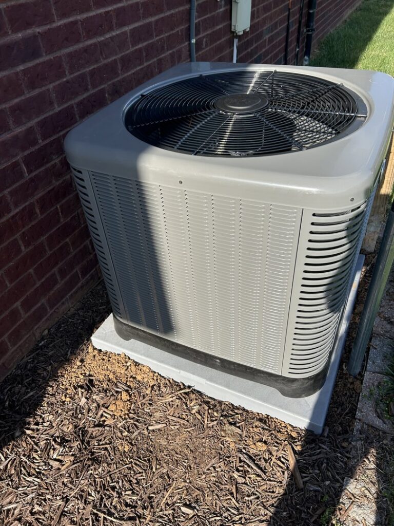 A newly installed outdoor HVAC condenser unit next to a brick wall by Top Notch Heating and Air Conditioning in Bowling Green, KY.