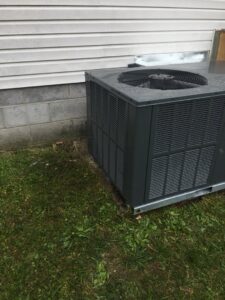 An outdoor HVAC condenser unit installed next to a residential building by Johnson's Heating and Cooling in Clarksville, TN.