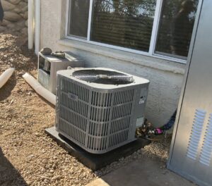 A newly installed or serviced outdoor HVAC condenser unit next to a residential building by Blue Collar Mechanical LLC in Indianapolis, IN.
