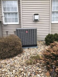 An outdoor HVAC condenser unit installed next to a residential home by Cool Tech Heating & Cooling in East Peoria, IL.