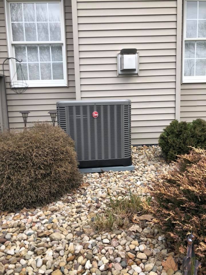An outdoor HVAC condenser unit installed next to a residential home by Cool Tech Heating & Cooling in East Peoria, IL.