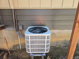 An outdoor HVAC condenser unit installed next to a residential building by Service Kings Heating and Air in Jamestown, ND.