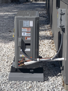 An outdoor HVAC condenser unit professionally installed by Symbiont Services in Englewood, FL.