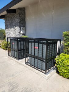 Two outdoor HVAC condenser units with protective cages, serviced by All Pro Air in Warrenville, IL.