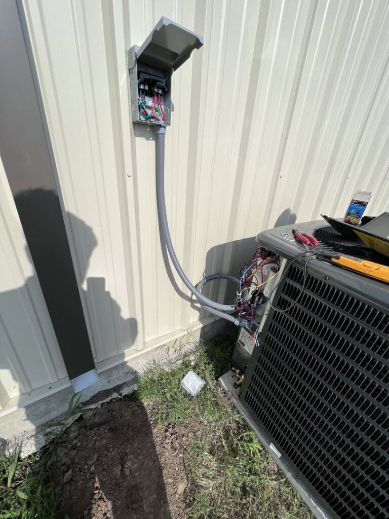 An outdoor electrical disconnect box and exposed wiring on an HVAC unit, showing electrical service by Quistian Lighting in Arlington, TX