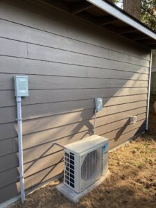 An outdoor HVAC unit with new electrical conduit and disconnect box by Good Contact Electric, LLC in Tacoma, WA.