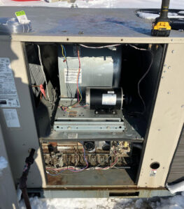 An outdoor HVAC furnace unit with internal components exposed during service by Schomp's Mechanical Services in Brookings, SD.