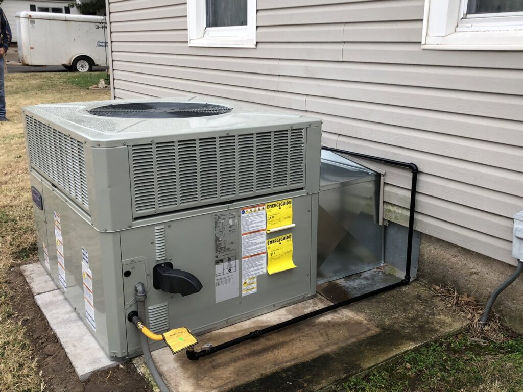 An outdoor HVAC package unit installation with gas line connection next to a residential home by Crouch's Heating & Cooling LLC in Stillwater, OK.