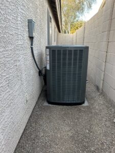 An outdoor HVAC unit installed next to a residential building by Advanced Comfort A/C & Heating in Phoenix, AZ.