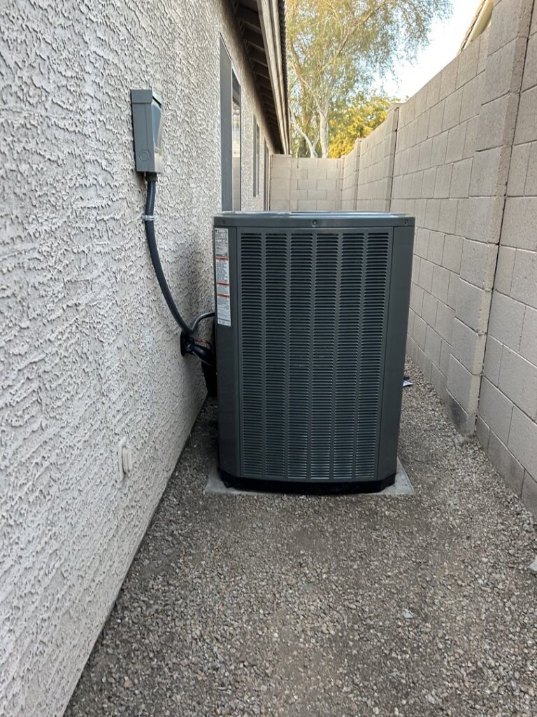 An outdoor HVAC unit installed next to a residential building by Advanced Comfort A/C & Heating in Phoenix, AZ.