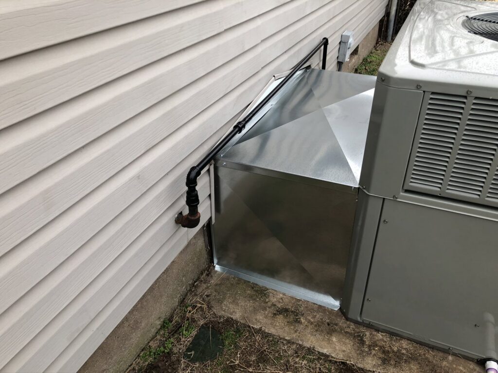 An outdoor HVAC unit with custom sheet metal ductwork transition installed by Crouch's Heating & Cooling LLC in Stillwater, OK.