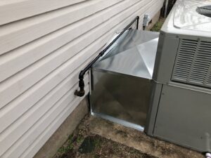 An outdoor HVAC unit with custom sheet metal ductwork transition installed by Crouch's Heating & Cooling LLC in Stillwater, OK.