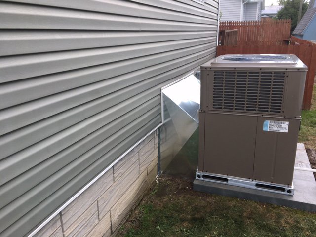 An outdoor HVAC unit with new ductwork connecting to a home, installed by Dodrill Comfort & Energy Solutions in Cross Lanes, WV