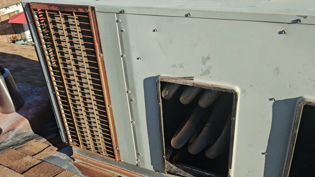 A close-up view of an outdoor HVAC unit's coils and components during an inspection by Alien Air Conditioning and Heating in Phoenix, AZ.