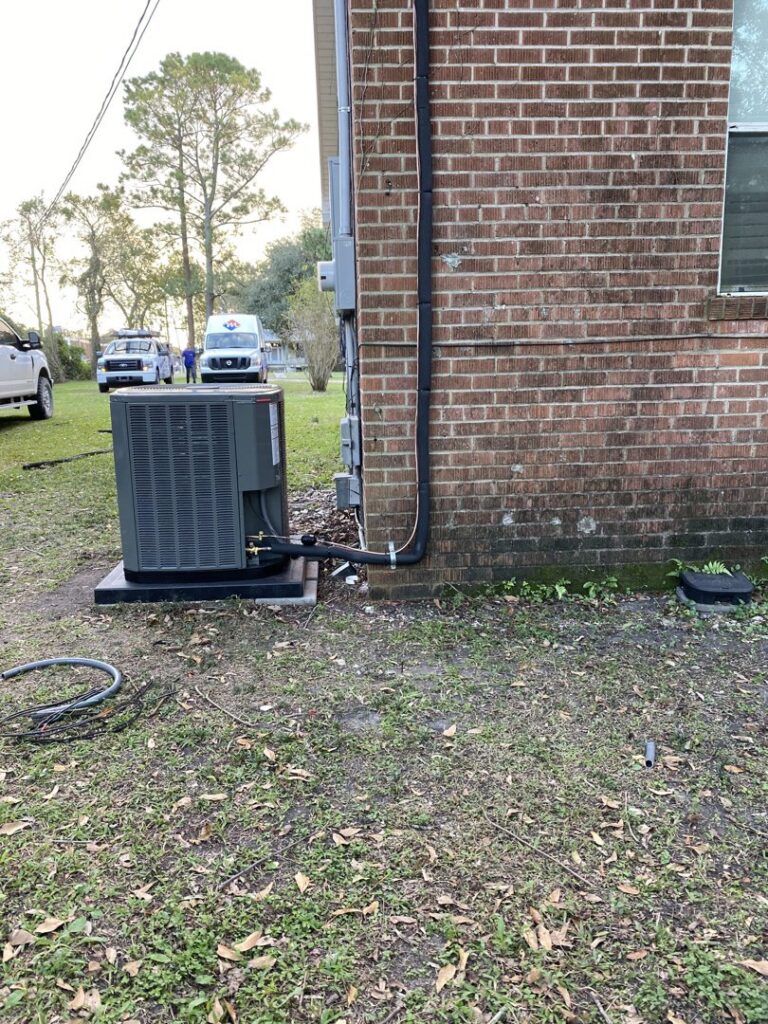 An outdoor HVAC unit installation next to a brick building by Alpha HVAC LLC in Alexandria, LA.