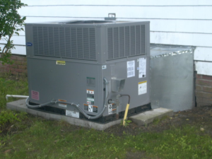 An outdoor HVAC unit installed next to a residential building by Collis Mechanical Services in Norfolk, VA