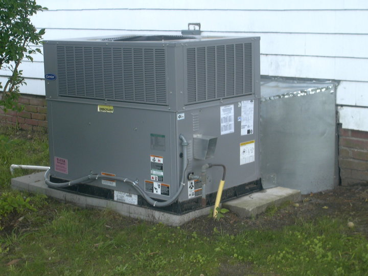 An outdoor HVAC unit installed next to a residential building by Collis Mechanical Services in Norfolk, VA