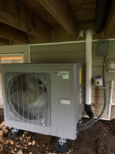 An outdoor GREE Inverter HVAC unit newly installed next to a residential building by Comfitrust in Boston, MA