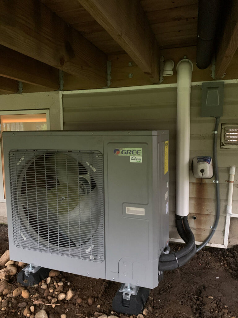 An outdoor GREE Inverter HVAC unit newly installed next to a residential building by Comfitrust in Boston, MA