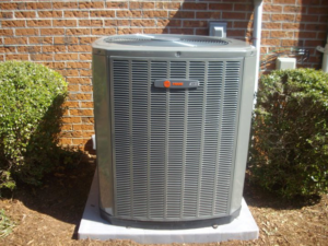 An outdoor HVAC unit installed next to a brick house by Moss Heating and Air in Greenville, SC