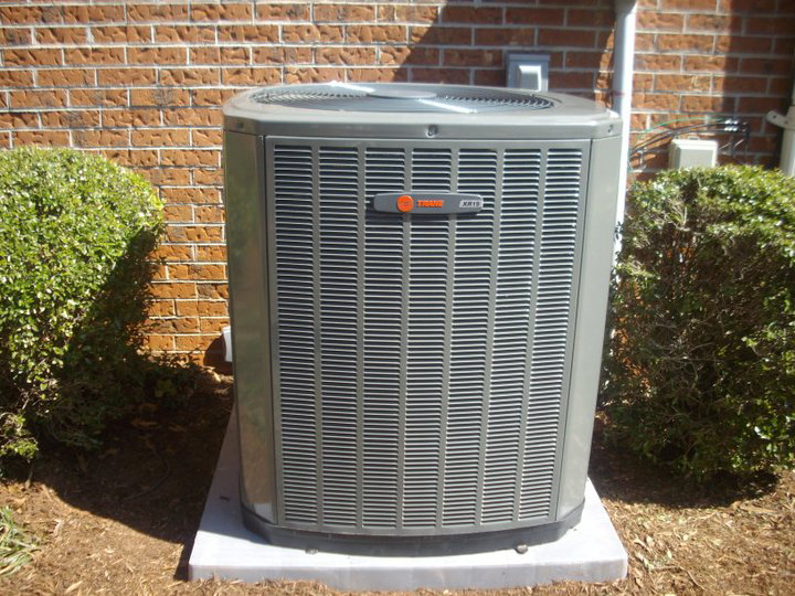 An outdoor HVAC unit installed next to a brick house by Moss Heating and Air in Greenville, SC