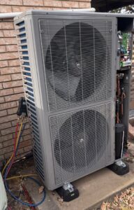 An outdoor HVAC unit with refrigerant lines and gauges, indicating installation or service by Dowd Heat & Air in Tulsa, OK.
