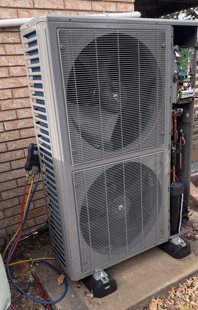 An outdoor HVAC unit with refrigerant lines and gauges, indicating installation or service by Dowd Heat & Air in Tulsa, OK.