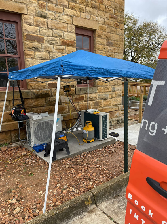 Outdoor HVAC units being installed or serviced under a canopy by Intek Heating + Air in Little Rock, AR.