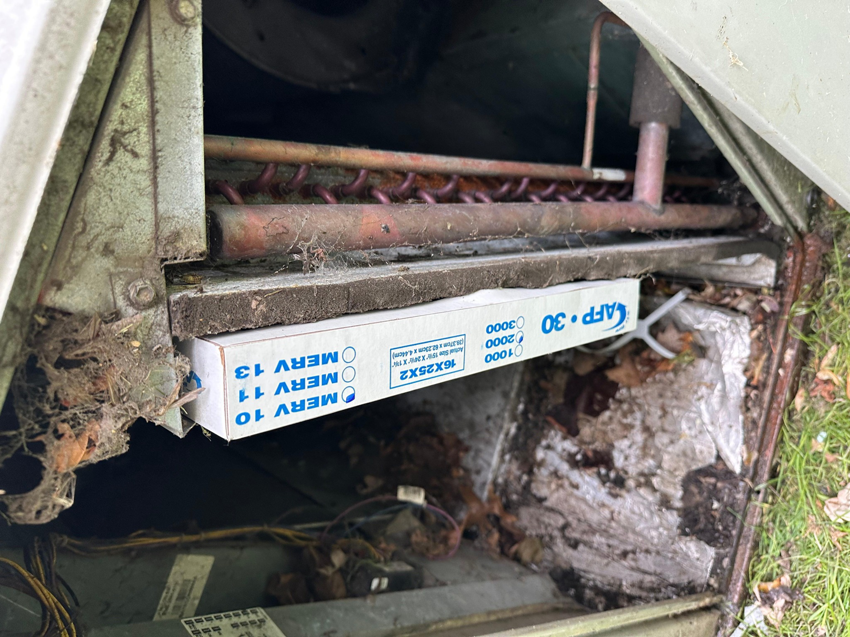 Inside an outdoor HVAC unit showing coils and a newly installed air filter by Cardinal Repairs in Canton, OH