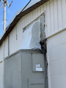 An outdoor HVAC unit with a poorly sealed connection to the building, a common issue addressed by Uplifting Air, LLC in San Antonio, FL.