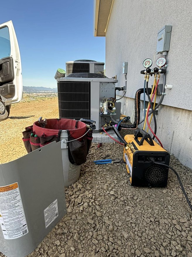 An outdoor HVAC unit being serviced with gauges and professional tools by Tropic Air Inc in Romulus, MI.