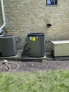 Two outdoor HVAC condenser units and a generator installed by Carpenter Mechanical in Columbus, OH.